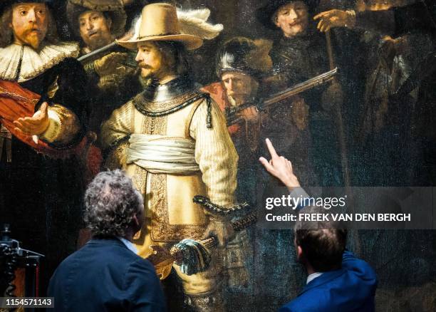 Restorers look at Rembrandt van Rijn's world-famous masterpiece "the Night Watch" in Amsterdam, on July 8, 2019. - Amsterdam's famed Rijksmuseum...