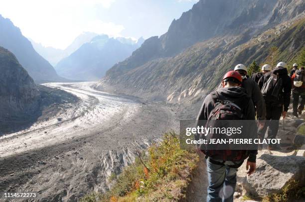 Des personnes participent à une opération de nettoyage du glacier de la Mer de glace, le 11 septembre 2009 près de Chamonix Mont-Blanc, lors d'une...