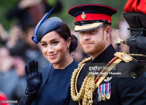 Prince Harry, Duke of Sussex and Meghan, Duchess of Sussex ride by carriage down the Mall during Trooping The Colour, the Queen's annual birthday...