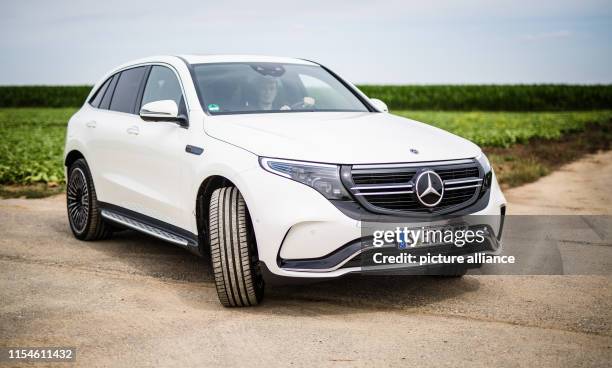 July 2019, Baden-Wuerttemberg, Stuttgart: A Mercedes-Benz EQC 400 Elekto-SUV drives over a country road. The car was presented today by Daimler at a...