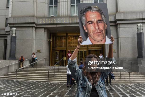 Protest group called "Hot Mess" hold up signs of Jeffrey Epstein in front of the federal courthouse on July 8, 2019 in New York City. According to...