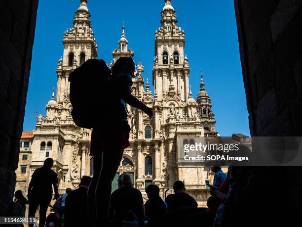 Pilgrim looks at the cathedral in Santiago de Compostela. The Camino de Santiago is a large network of ancient pilgrim routes stretching across...