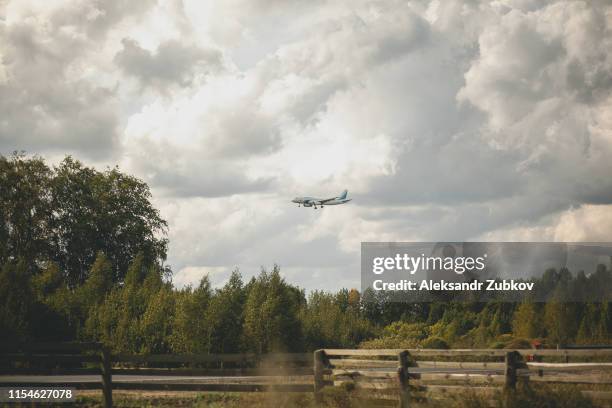 the plane flies over the forest. clouds in the sky - plane landing stock-fotos und bilder