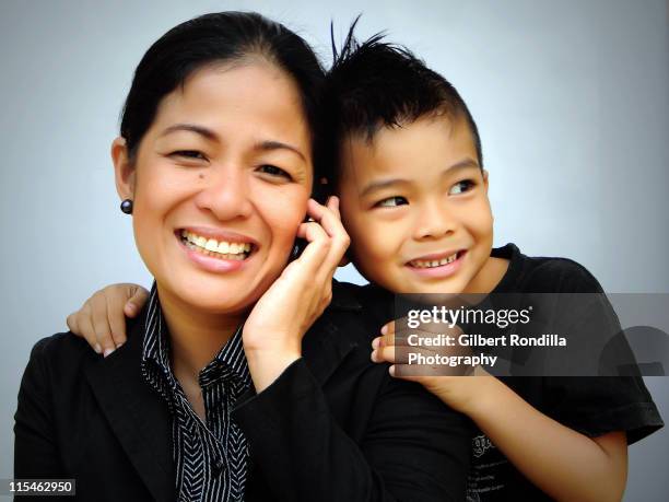 boy listening to mother talking on phone - philippines family imagens e fotografias de stock