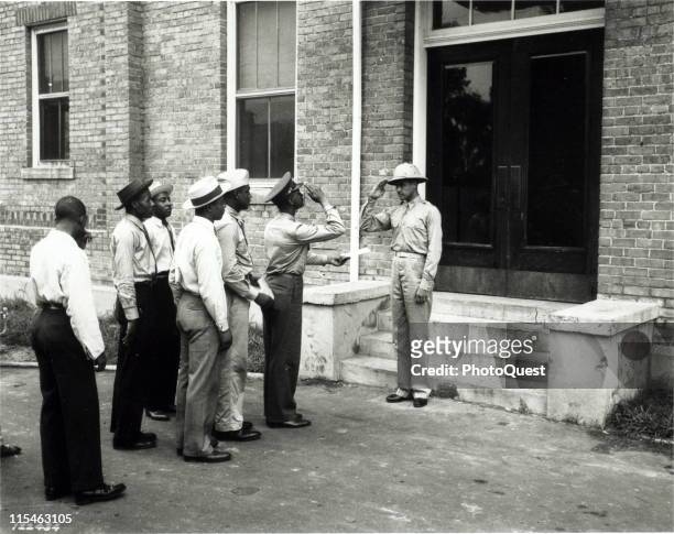 At the Tuskegee Field, Air Corps cadets salute as they report to Captain Benjamin O. Davis, Jr., Commandant of Cadets, September 1941.