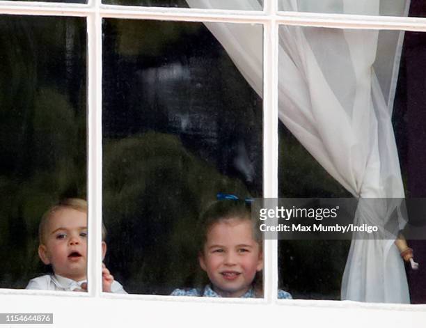 Prince Louis of Cambridge and Princess Charlotte of Cambridge look out of a window of Buckingham Palace as they attend Trooping The Colour, the...