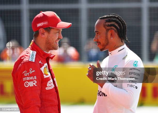 Pole position qualifier Sebastian Vettel of Germany and Ferrari and second place qualifier Lewis Hamilton of Great Britain and Mercedes GP talk in...