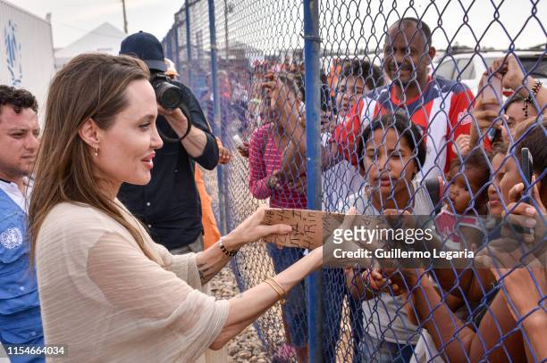 United Nations High Commissioner for Refugees Special Envoy Angelina Jolie greets people during her visit to a refugee camp in the border between...