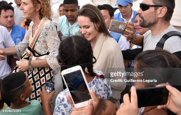 United Nations High Commissioner for Refugees Special Envoy Angelina Jolie greets children during her visit to a refugee camp in the border between...