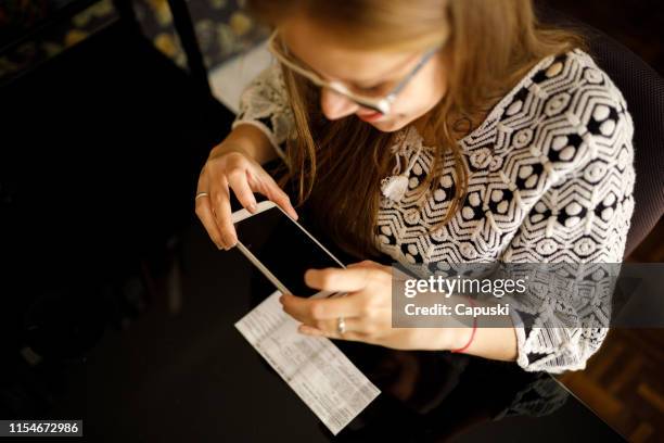 woman depositing check by phone - cheque deposit stock pictures, royalty-free photos & images