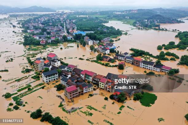This aerial picture taken on July 9, 2019 shows submerged buildings after heavy rain caused flooding in Hengyang in central China's Hunan province. /...