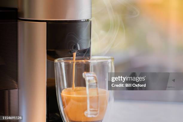 coffee maker pouring into glass mug - coffee machine stock pictures, royalty-free photos & images