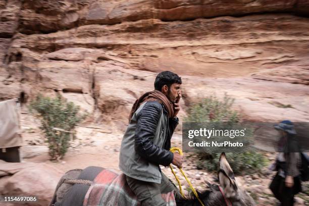 Bedouin riding his donkey on the way between Monastery and Siq. Petra, ancient Nabatean capital,, UNESCO World Heritage Site since 1985. In 2007,...