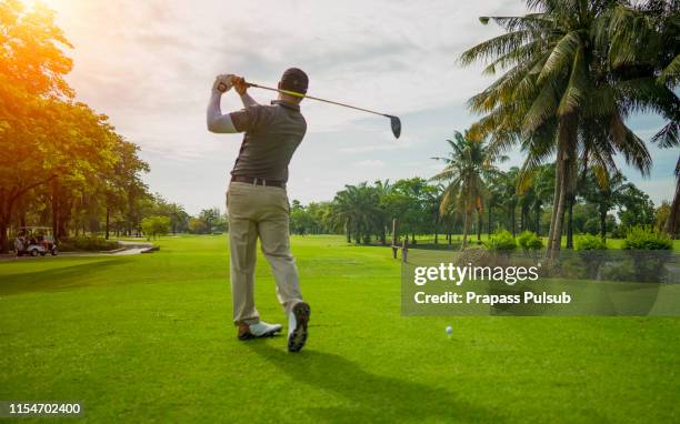 golfer putting golf ball on the green golf, lens flare on sun set evening time - asian flags ストックフォトと画像