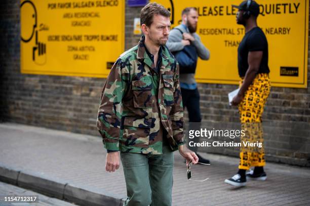 Guest is seen wearing camouflage jacket outside Iceberg during London Fashion Week Men's June 2019 on June 08, 2019 in London, England.