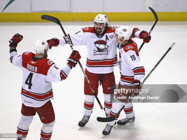 Trevor Carrick of the Charlotte Checkers celebrates a third period goal with Josiah Didier and Morgan Geekie against the Chicago Wolves during game...