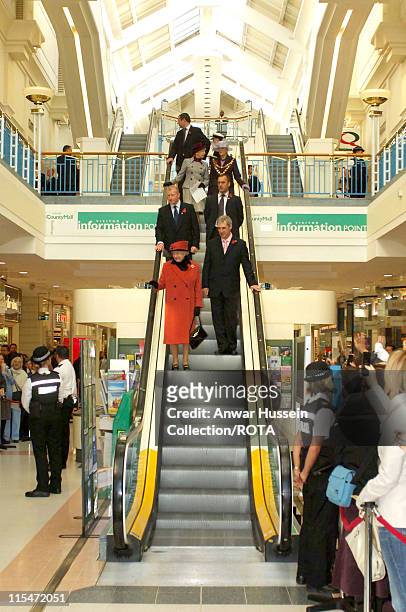 Queen Elizabeth II rides down an escalator as she visits County Mall in Crawley, West Sussex on 3 November, 2006. The Queen has scaled back her...