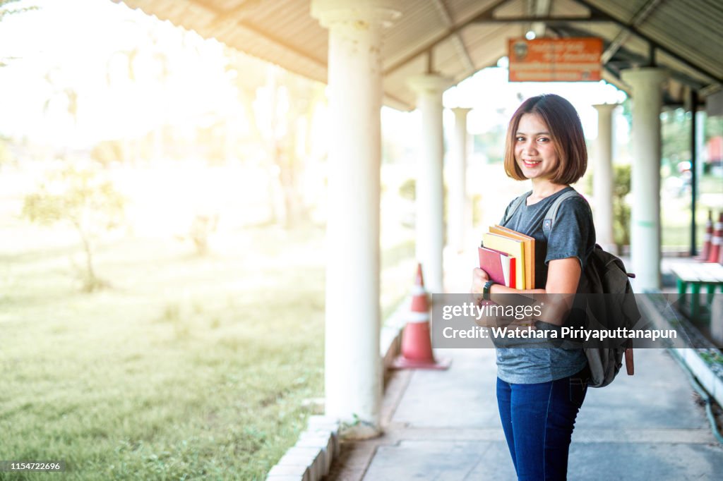 Young asia student holding books at unversity.