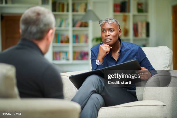 therapist in counselling session - androgynous professional stock pictures, royalty-free photos & images