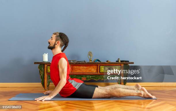 man on cobra pose on the mat - cobra stretch stock pictures, royalty-free photos & images