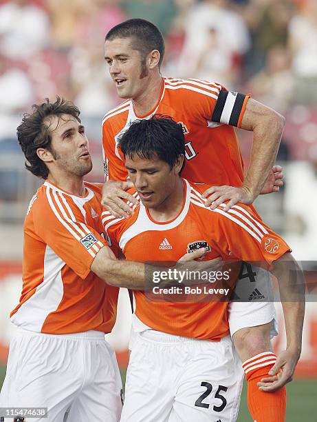 Houston's Brian Ching is congratlulated by Wade Barrett and Brian Mullan after his second goal during first half action between the Colorado Rapids...