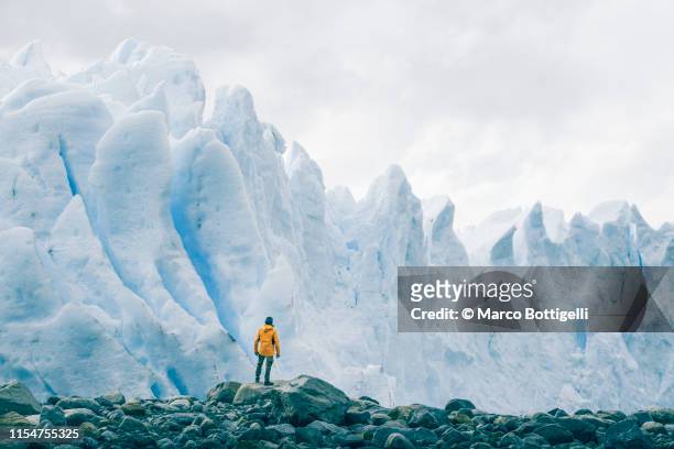 tourist admiring the perito moreno glacier, argentina - maestosità foto e immagini stock