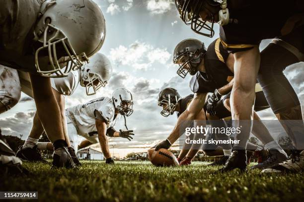 unten blick auf amerikanische fußballspieler auf einen anfang der partie. - amerikanischer football stock-fotos und bilder