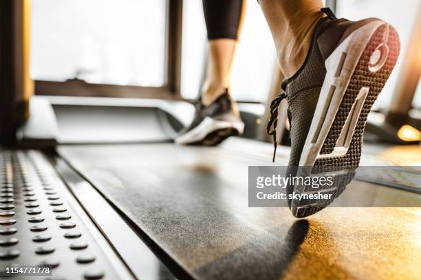cerca de atleta irreconocible corriendo en una caminadora en un gimnasio. - treadmill fotografías e imágenes de stock