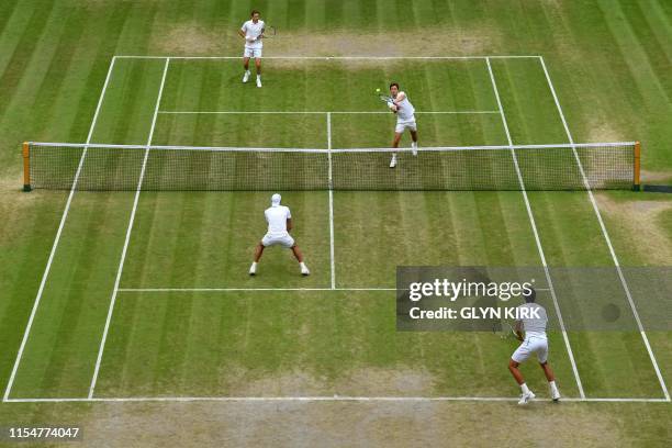 France's Nicolas Mahut and France's Edouard Roger-Vasselin return against Poland's Lukasz Kubot and Brazil's Marcelo Melo during their men's doubles...