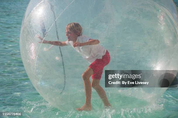 young boy in a water zorb - water walking ball stock pictures, royalty-free photos & images