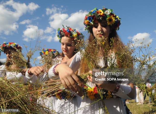 Women weave wreaths of wild flowers during a celebration in Kiev. Kupala Night, also known as Ivan Kupala Day, is a Ukrainian observance annually...