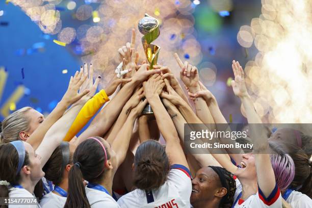 Women's World Cup Final: View of USA team players' arms victorious reaching for FIFA World Cup trophy after winning game vs Netherlands at Parc...