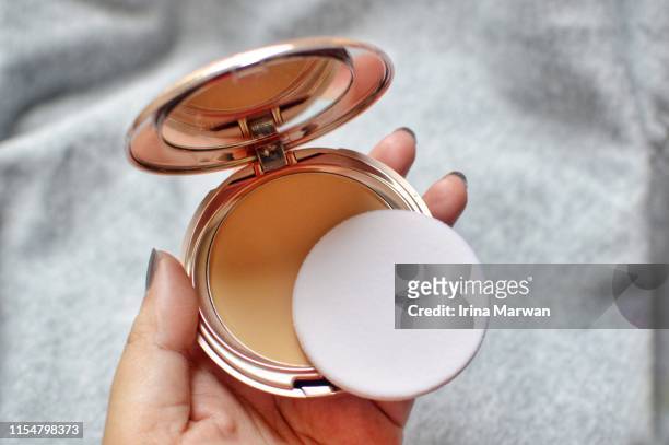 make-up products: hand holding compact powder - compact mirror stockfoto's en -beelden