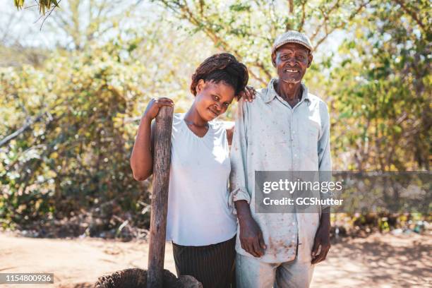 african village girl steht neben ihrem vater - rural africa family stock-fotos und bilder