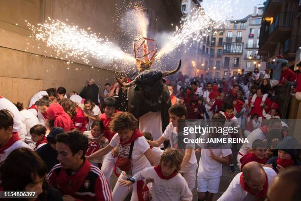 Man wearing a costume of "Toro de Fuego" chases people during the San Fermin Festival on July 9 in Pamplona, northern Spain.