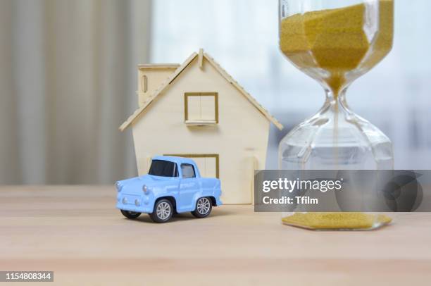 home model, car toy with hourglass, property for sale or buy concept. - car sale stockfoto's en -beelden