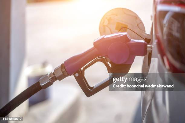 fuel oil gasoline dispenser at petrol filling station.holding fuel nozzle to refuel gasoline for car. - bensin bildbanksfoton och bilder