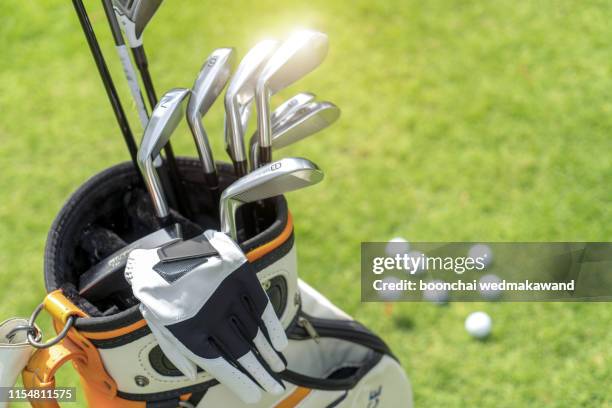 golf ball and golf club in bag on green grass - golf caddy stock-fotos und bilder