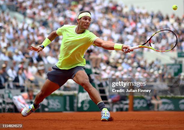 Rafael Nadal of Spain stretches for a backhand during the mens singles final against Dominic Thiem of Austria during Day Fifteen of the 2019 French...
