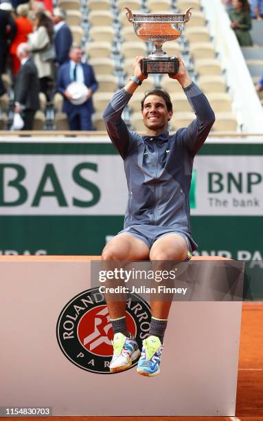 Rafael Nadal of Spain lifts up the trophy after defeating Dominic Thiem of Austria in the final during Day Fifteen of the 2019 French Open at Roland...