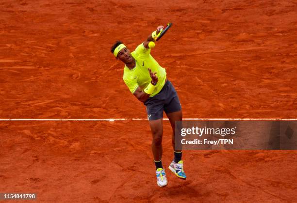 Rafael Nadal hits a forehand smash against Dominic Thiem of Austria in the final of the men's singles during Day 15 of the 2019 French Open at Roland...