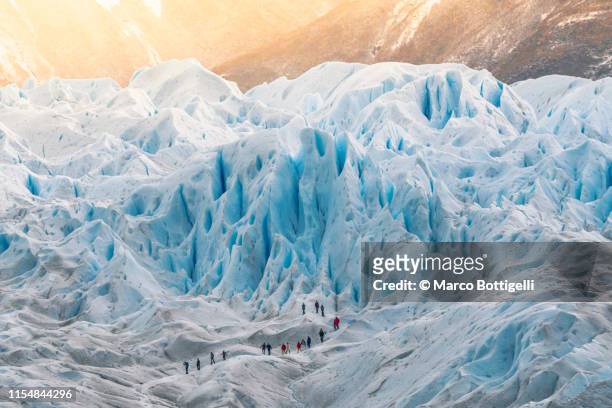 group of people hiking on the perito moreno glacier, argentina - internationaal monument stockfoto's en -beelden