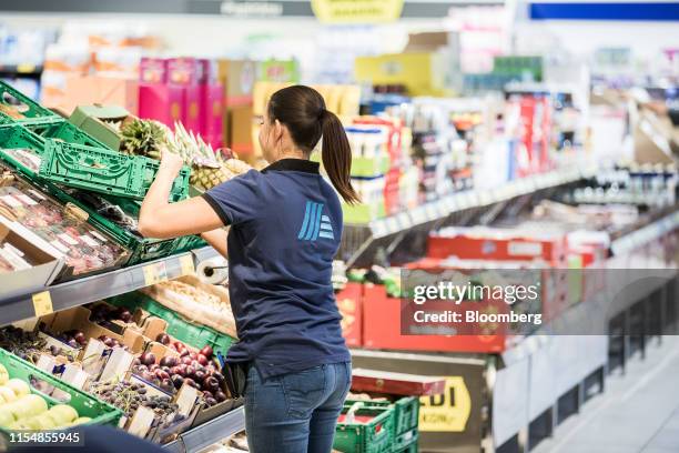 An employee arranges crates of fresh produce in the fruit and vegetable aisle inside an Aldi Stores Ltd. Grocery store in Ullo, Hungary, on Monday,...