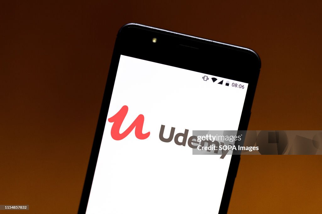 In this photo illustration a Udemy logo seen displayed on a...