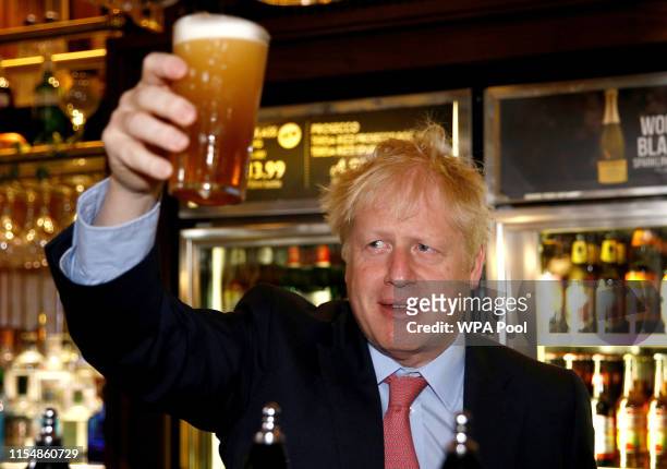 Boris Johnson, a leadership candidate for Britain's Conservative Party holds a pint of beer as he meets with JD Wetherspoon chairman, Tim Martin at...