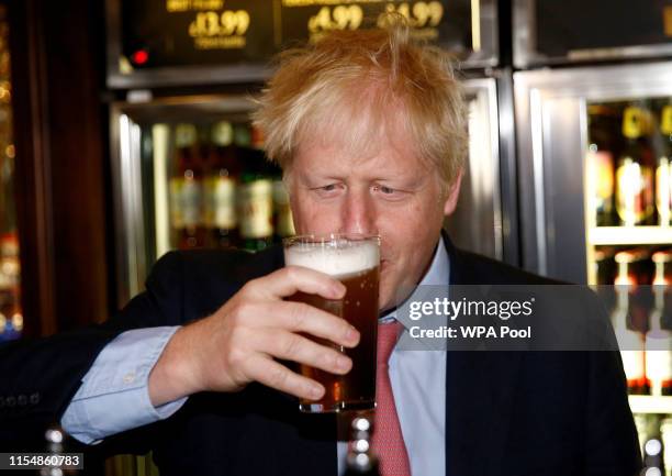 Boris Johnson, a leadership candidate for Britain's Conservative Party tastes a pint of beer as he meets with JD Wetherspoon chairman, Tim Martin at...