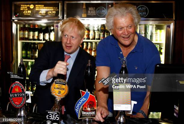 Boris Johnson, a leadership candidate for Britain's Conservative Party pulls a pint as he meets with JD Wetherspoon chairman, Tim Martin at...
