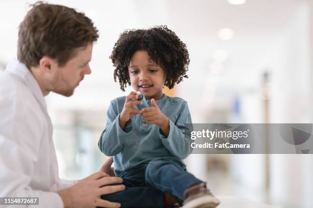 toddler boy with asthma learns to use inhaler - reliever asthma inhaler stock pictures, royalty-free photos & images