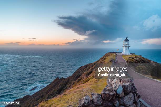 sunset at cape reinga. - cape reinga lighthouse stock pictures, royalty-free photos & images