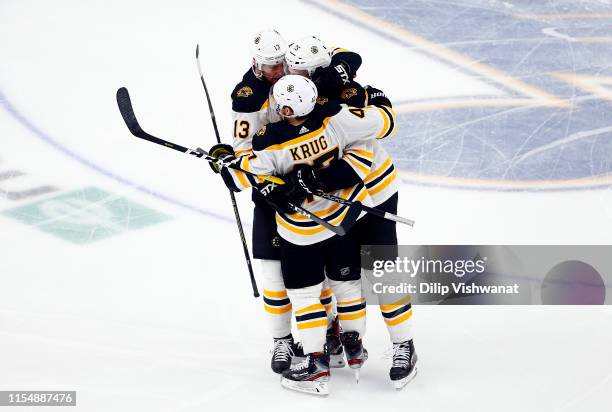 Brandon Carlo of the Boston Bruins is congratulated by his teammates Charlie Coyle and Torey Krug after scoring a third period goal against the St....